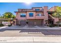 Townhouse with a three-car garage, stone accents, and a stucco facade providing curb appeal at 20660 N 40Th St # 2016, Phoenix, AZ 85050