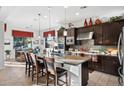 Spacious kitchen with dark wood cabinets, a large island with seating, and stainless steel appliances at 30224 N 52Nd Pl, Cave Creek, AZ 85331