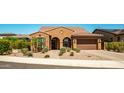 Charming single-story home featuring a tile roof, arched entryway, desert landscaping, and a two-car garage at 30876 N 128Th Dr, Peoria, AZ 85383