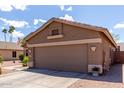 Side view of a tan single-story home featuring a two-car garage, desert landscaping, and blue skies at 3793 E Lexington Ave, Gilbert, AZ 85234
