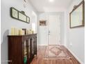 Inviting entryway featuring hardwood floors, decorative mirrors, and a stylish wooden cabinet at 40853 W Bravo Dr, Maricopa, AZ 85138
