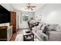 Comfortable living room area with hardwood floors, a sofa, desk, and ceiling fan at 40853 W Bravo Dr, Maricopa, AZ 85138