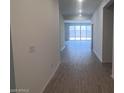 Inviting home hallway showcasing stylish wood-look flooring, leading to a bright and airy living space with sliding glass doors at 47253 W Pecan Woods --, Maricopa, AZ 85139