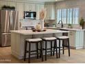 Bright kitchen features quartz island with seating, stainless steel appliances, and modern finishes at 5011 E Nisbet Rd, Scottsdale, AZ 85254