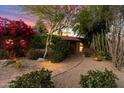 Inviting front entrance featuring a brick walkway, lush foliage, and a tiled roof under a colorful twilight sky at 5334 E Everett Dr, Scottsdale, AZ 85254