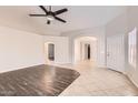 Spacious living room with dark-wood and tile flooring, neutral paint, and ample natural light through the front door at 7709 W Tonto Dr, Glendale, AZ 85308