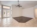 Bright living area with tile flooring, a ceiling fan, and a patio door to a back yard at 7709 W Tonto Dr, Glendale, AZ 85308