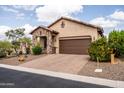 Charming home with a desert landscape, stone accents, paver driveway, and a two-car garage in a serene setting at 8804 E Ivy St, Mesa, AZ 85207