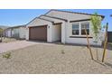 Picture of the house showing the neutral-toned stucco, brown trim, and the two car garage at 9547 W Parkway Dr, Tolleson, AZ 85353