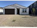 Charming single-story home featuring a well-maintained front yard and a two-car garage at 9547 W Parkway Dr, Tolleson, AZ 85353