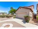 Beige house with large garage and desert plants in front of a paved two car driveway at 10225 W Camelback Rd # 3, Phoenix, AZ 85037
