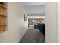 Hallway with carpet flooring that leads to living area with large sliding glass doors at 10429 W Oakmont Dr, Sun City, AZ 85351