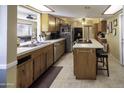 Bright kitchen with tile flooring, a breakfast bar, and wooden cabinetry at 1209 W Tulane Dr, Tempe, AZ 85283