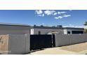 View of the backyard with a private black gate, fence, shed, and desert landscaping at 12805 W Colter St, Litchfield Park, AZ 85340