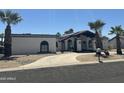 A charming single-story home with a private drive, desert landscaping, and mature palm trees at 12805 W Colter St, Litchfield Park, AZ 85340