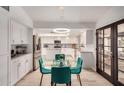 Bright kitchen with white cabinetry, stainless steel appliances, and an adjacent dining area with stylish blue chairs at 12805 W Colter St, Litchfield Park, AZ 85340