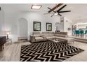 Spacious living room with a comfortable sectional sofa, modern ceiling fan, and an open layout to the kitchen at 12805 W Colter St, Litchfield Park, AZ 85340