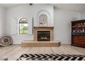 Cozy living room showcasing a tiled fireplace, arched window, and decorative wine rack, creating a relaxing ambiance at 12805 W Colter St, Litchfield Park, AZ 85340