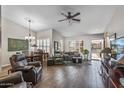 Spacious living room with hardwood floors, a ceiling fan, and abundant natural light from the windows at 13608 W Aleppo Dr, Sun City West, AZ 85375