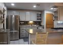 A well-lit kitchen featuring stainless steel appliances, gray cabinetry and decorative backsplash at 14439 N 38Th Pl, Phoenix, AZ 85032