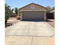 Charming single-story home featuring a two-car garage and desert landscaping at 15023 W Redfield Rd, Surprise, AZ 85379