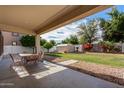 Relaxing covered patio overlooks a spacious backyard with lush green grass and a storage shed at 15028 W Minnezona Ave, Goodyear, AZ 85395