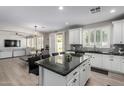 Bright, open kitchen features white cabinets, granite countertops, an island, and an eat-in kitchen at 15028 W Minnezona Ave, Goodyear, AZ 85395