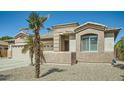 Close up of tan home featuring desert landscaping and an arched window with white blinds at 15211 N 184Th Ct, Surprise, AZ 85388