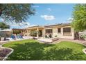 A luxurious backyard featuring artificial turf, a patio, outdoor furniture, and desert landscaping, creating a relaxing oasis at 15849 W Alvarado Dr, Goodyear, AZ 85395