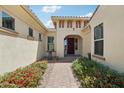 Eye-catching entrance with a brick walkway bordered by colorful flowering plants leading to the home's front door at 15849 W Alvarado Dr, Goodyear, AZ 85395