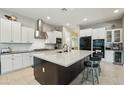 A modern kitchen featuring white cabinets, stainless steel appliances, and a spacious dark wood island with light countertop at 15849 W Alvarado Dr, Goodyear, AZ 85395