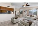 Open-concept living room and dining area with neutral decor and tile floors at 17912 N 88Th Dr, Peoria, AZ 85382