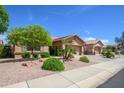 Well-maintained home exterior featuring a tiled roof, desert landscaping, and attached garages at 17958 W Udall Dr, Surprise, AZ 85374