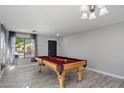 Bright game room featuring a wooden pool table with red felt, complemented by gray tile floors and neutral walls at 1887 W Desert Seasons Dr, Queen Creek, AZ 85144