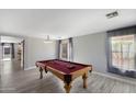 Spacious game room featuring a pool table, gray tile floors, neutral paint and two bright windows at 1887 W Desert Seasons Dr, Queen Creek, AZ 85144