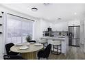 Bright open-concept kitchen and dining area featuring a marble island with seating and stainless steel appliances at 1961 N Hartford St # 1162, Chandler, AZ 85225