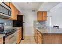 Bright kitchen with stainless steel appliances, granite countertops, tile backsplash, and tile floors at 200 E Southern Ave # 222, Tempe, AZ 85282