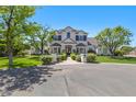 Beautiful two-story home with a manicured lawn, decorative shrubbery and a circular driveway in a suburban setting at 23902 S 202Nd Ct, Queen Creek, AZ 85142