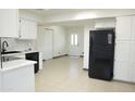 Spacious kitchen with white cabinets and a black refrigerator, and a view to the front door at 2902 W Bloomfield Rd, Phoenix, AZ 85029