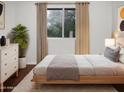 Well-lit bedroom featuring a large window with green outdoor views and neutral color palette at 5976 W Alameda Rd, Glendale, AZ 85310