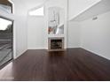 Bright living room with a vaulted ceiling, cozy fireplace, and attractive dark wood floors at 5976 W Alameda Rd, Glendale, AZ 85310