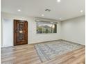 Entryway features light wood floors, area rug, and a decorative wood front door at 6002 E Cholla Rd, Cave Creek, AZ 85331