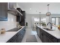 Modern kitchen with marble countertops, dark wood cabinets, stainless hood, and open to dining area at 6509 W Apex Ave, Queen Creek, AZ 85144