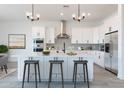 Modern kitchen boasts a large island with seating, stainless steel appliances, and sleek white cabinetry at 6564 W Apex Ave, Queen Creek, AZ 85144