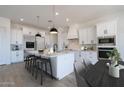 Bright modern kitchen featuring stainless steel appliances, white cabinetry, and a center island with seating at 6579 W Apex Ave, Queen Creek, AZ 85144