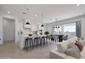 Open-concept kitchen with white cabinetry, island seating, and adjacent dining area with dark wood table at 6579 W Apex Ave, Queen Creek, AZ 85144