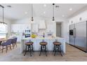 Bright, open kitchen with stainless steel appliances, a large island, and modern pendant lighting at 6604 W Apex Ave, Queen Creek, AZ 85144