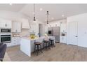 This open kitchen has white cabinets, stainless steel appliances, and a breakfast bar with stool seating at 6604 W Apex Ave, Queen Creek, AZ 85144