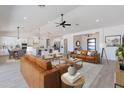 Open-concept living room with hardwood floors, a ceiling fan, and seamless access to the kitchen at 6604 W Apex Ave, Queen Creek, AZ 85144