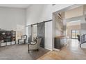 Open-concept living room with high ceilings, sliding barn doors, and neutral decor at 6901 W Tonto Dr, Glendale, AZ 85308